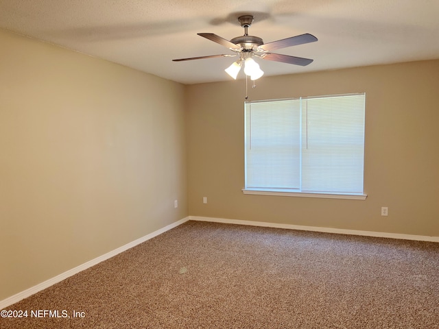 unfurnished room featuring ceiling fan and carpet