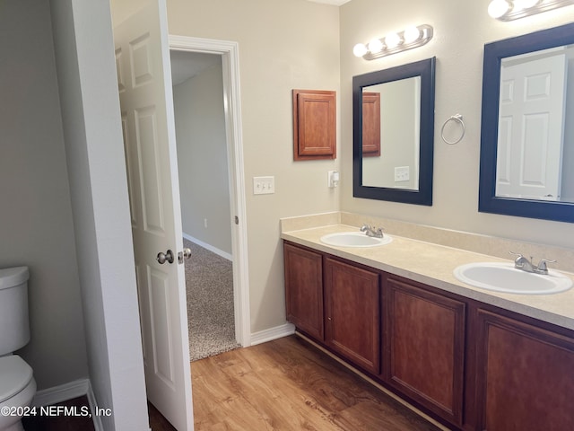 bathroom with vanity, toilet, and wood-type flooring