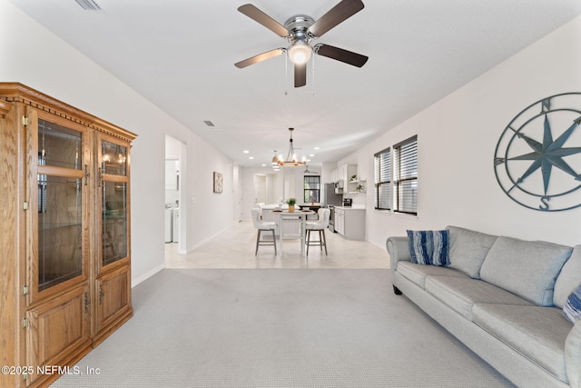 carpeted living room featuring ceiling fan with notable chandelier