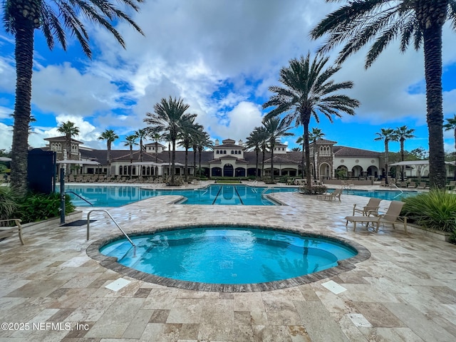 view of swimming pool with a community hot tub and a patio