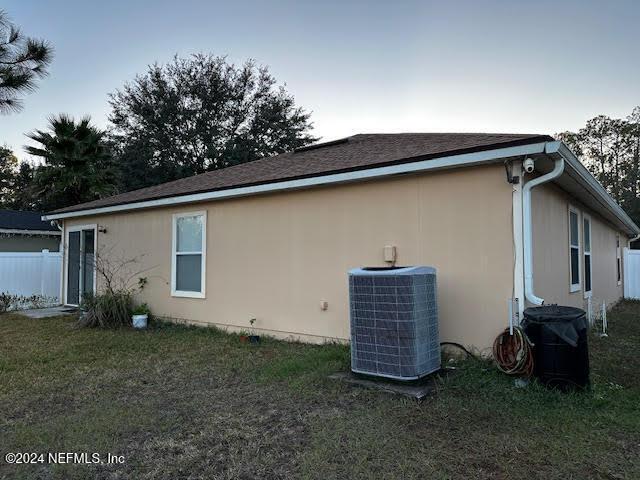 view of home's exterior featuring central air condition unit and a yard