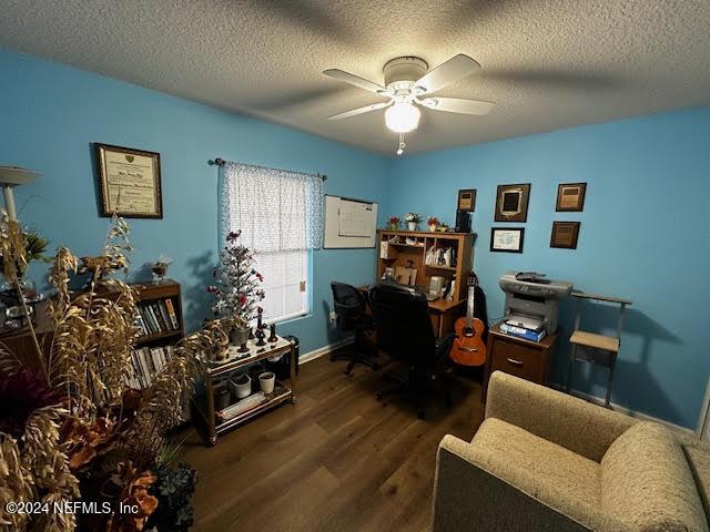 home office featuring ceiling fan, dark hardwood / wood-style flooring, and a textured ceiling