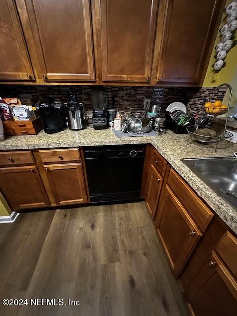 kitchen with dishwasher, dark hardwood / wood-style flooring, sink, and tasteful backsplash