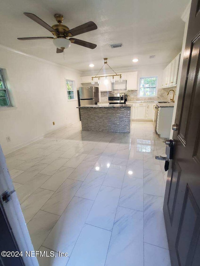 kitchen with white cabinets, sink, decorative backsplash, stainless steel fridge, and ornamental molding