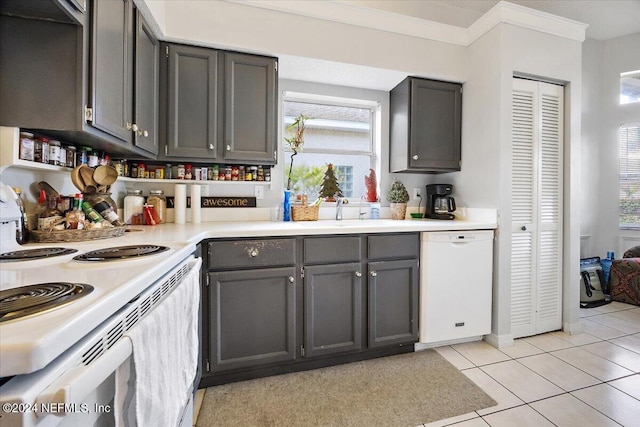 kitchen featuring light tile patterned floors, white appliances, sink, and a wealth of natural light