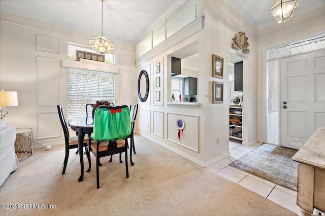 dining room featuring a chandelier, crown molding, and light colored carpet