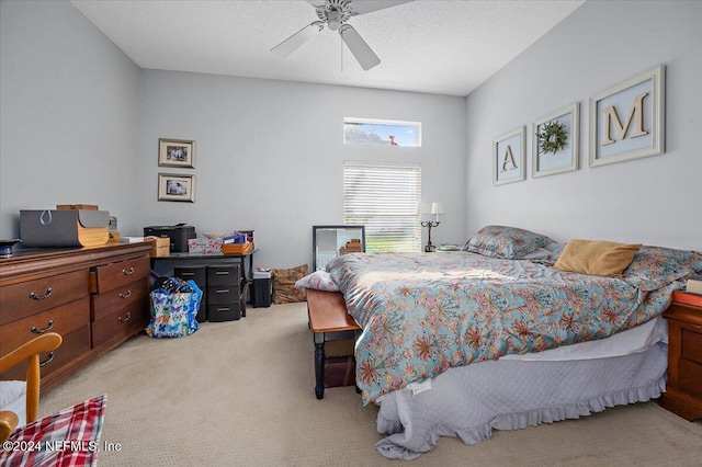 carpeted bedroom featuring ceiling fan and a textured ceiling