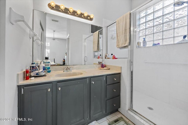 bathroom featuring vanity, tile patterned floors, ceiling fan, and a shower with shower door