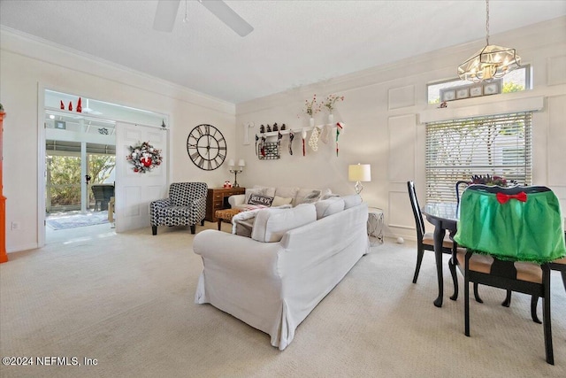 carpeted living room with ceiling fan with notable chandelier, a wealth of natural light, and crown molding