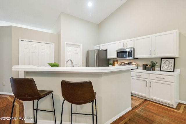 kitchen with white cabinetry, a kitchen island with sink, a breakfast bar area, and stainless steel appliances