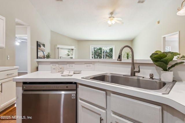 kitchen with dishwasher, lofted ceiling, white cabinets, sink, and ceiling fan