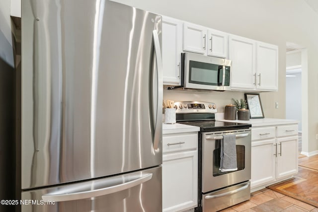 kitchen featuring light tile patterned floors, stainless steel appliances, and white cabinetry