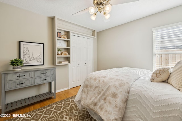 bedroom featuring ceiling fan, a closet, hardwood / wood-style floors, and a textured ceiling