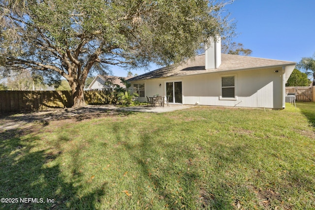 back of house with a yard and a patio