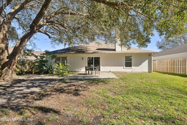 rear view of house with a lawn and a patio area