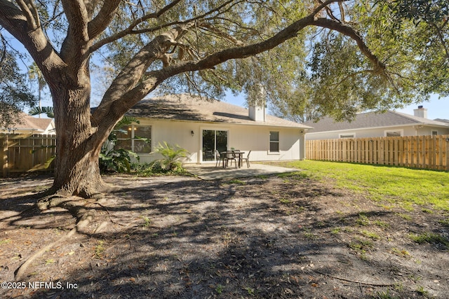 rear view of house with a lawn and a patio