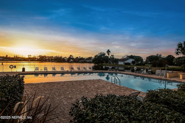 pool at dusk featuring a patio