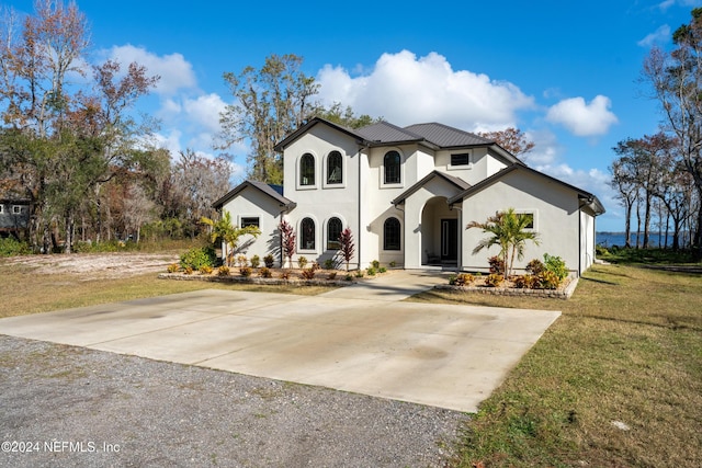 view of front of home featuring concrete driveway, a front yard, and stucco siding