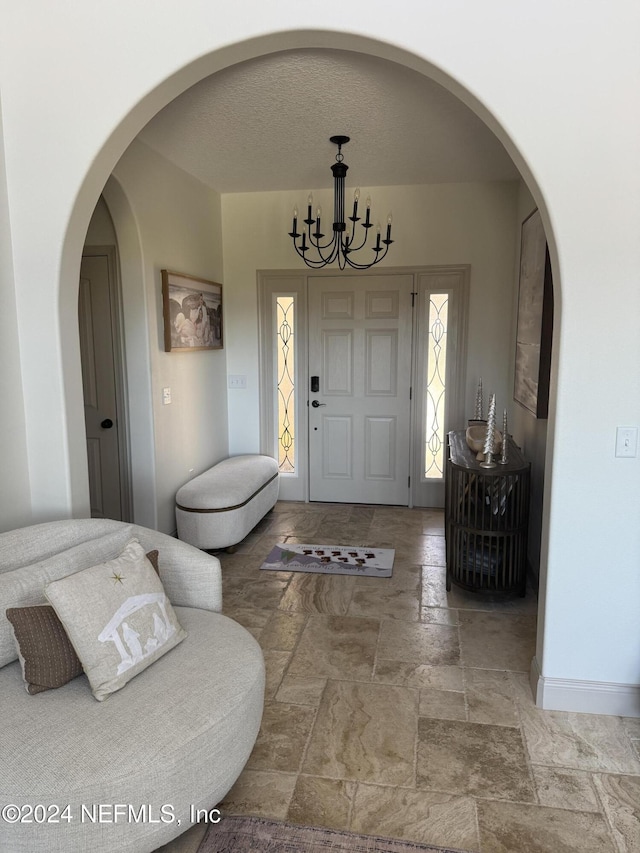 entrance foyer featuring a textured ceiling and a notable chandelier