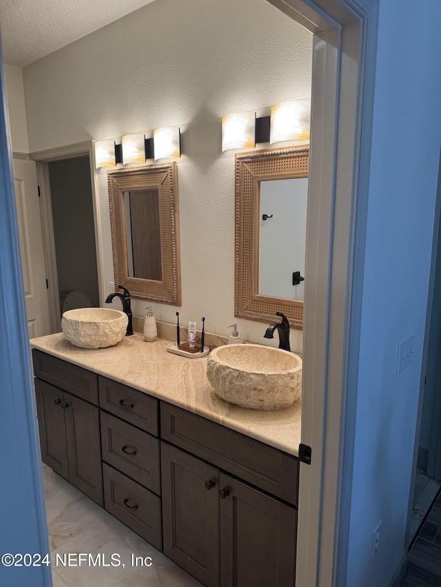 bathroom featuring a textured ceiling and vanity