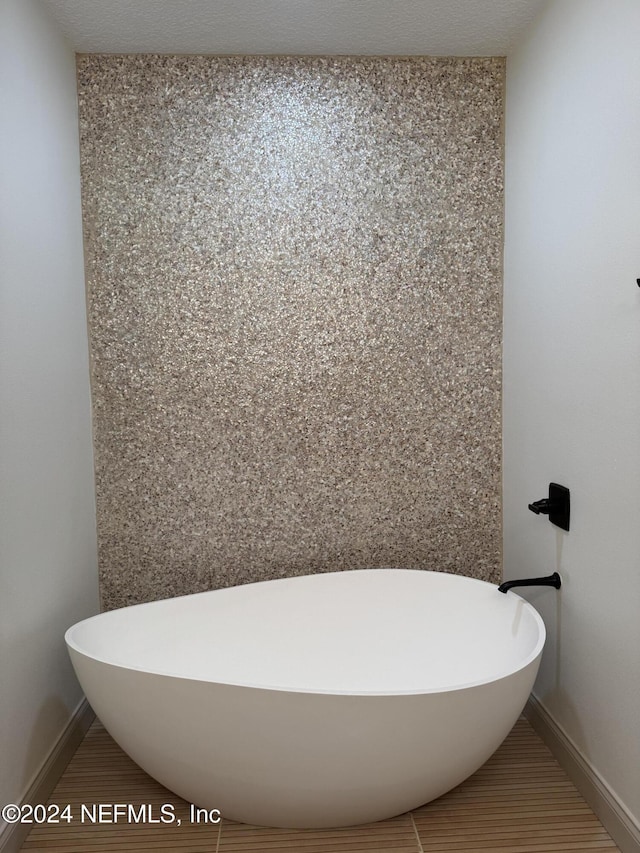 bathroom featuring a textured ceiling and a tub