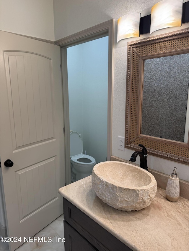 bathroom with tile patterned floors, vanity, and toilet