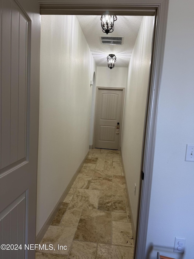 corridor with a textured ceiling