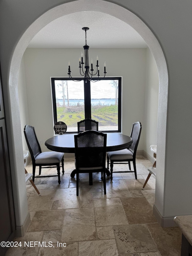 dining space featuring a chandelier, a textured ceiling, and plenty of natural light