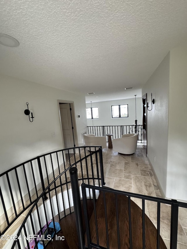 hall featuring a textured ceiling