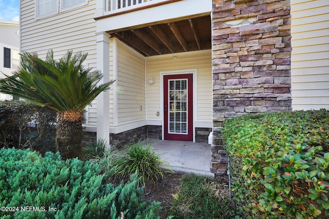 view of exterior entry featuring a balcony