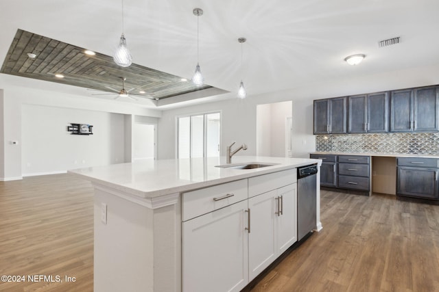 kitchen with tasteful backsplash, stainless steel dishwasher, sink, a center island with sink, and white cabinetry