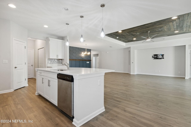 kitchen with ceiling fan with notable chandelier, stainless steel dishwasher, an island with sink, decorative light fixtures, and white cabinetry