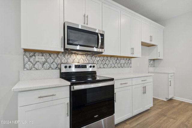 kitchen featuring light stone countertops, appliances with stainless steel finishes, light wood-type flooring, tasteful backsplash, and white cabinetry