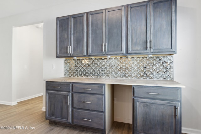 kitchen featuring decorative backsplash, dark brown cabinets, and light wood-type flooring