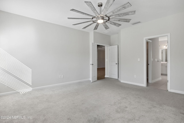 unfurnished bedroom with connected bathroom, ceiling fan, and light colored carpet