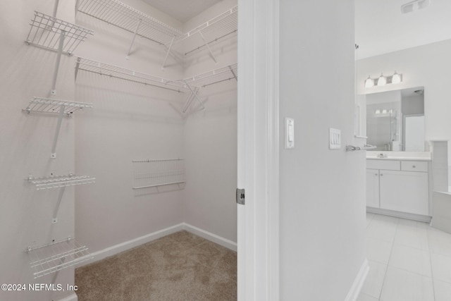 spacious closet with light tile patterned flooring and sink