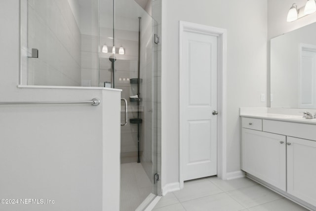 bathroom featuring tile patterned flooring, vanity, and a shower with door