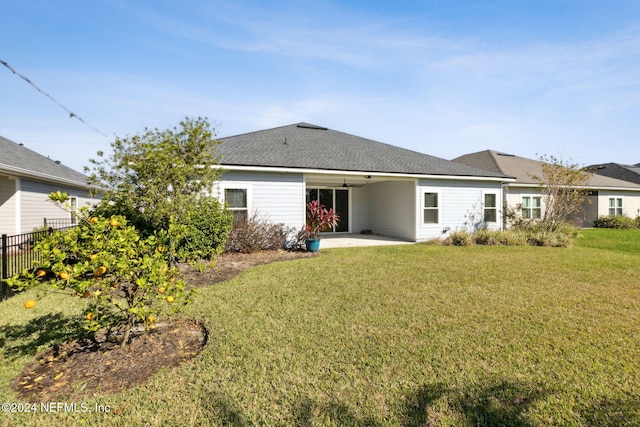 rear view of house with a patio, ceiling fan, and a lawn