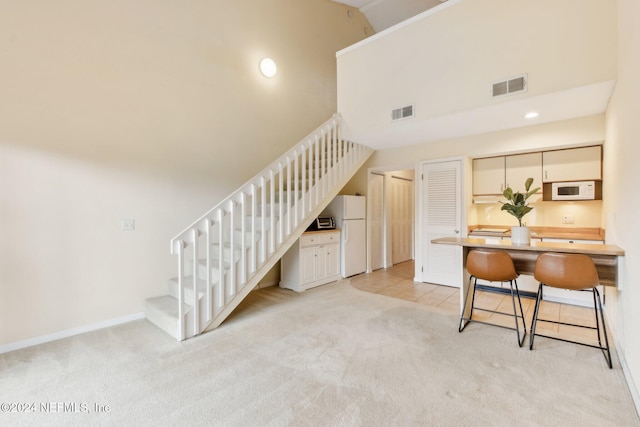 stairway with carpet flooring and a towering ceiling