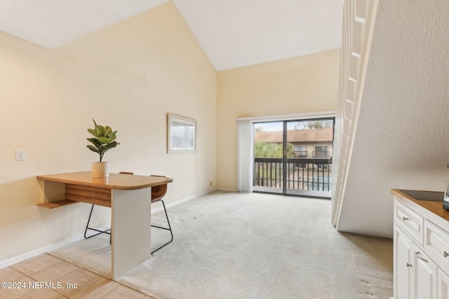 unfurnished office featuring light carpet and high vaulted ceiling