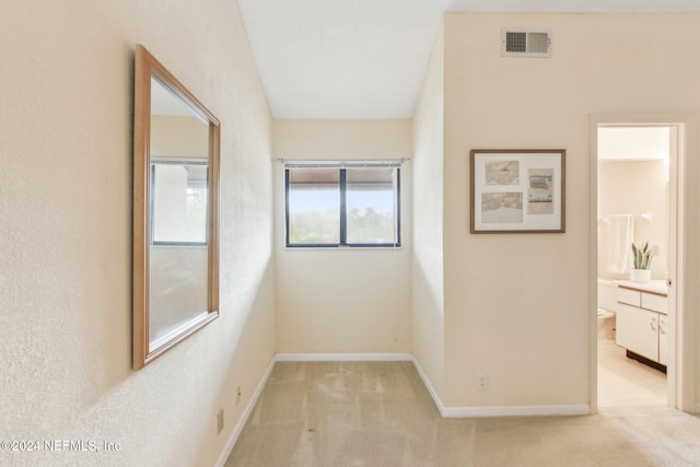 hall featuring light carpet