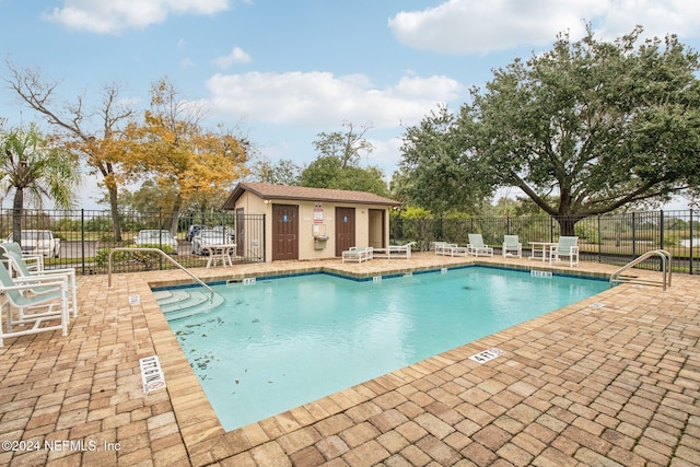 view of swimming pool with a patio area and an outbuilding