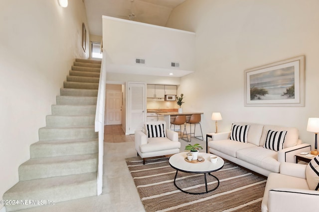 carpeted living room with a high ceiling