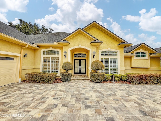 view of exterior entry featuring french doors and a garage