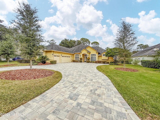 ranch-style house with a garage and a front lawn