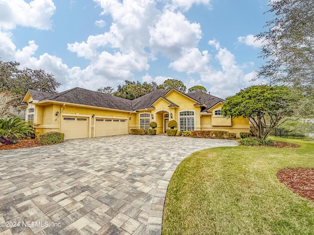 view of front of property with a garage and a front lawn