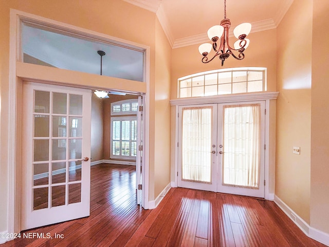 entryway featuring hardwood / wood-style floors, ceiling fan with notable chandelier, crown molding, and french doors