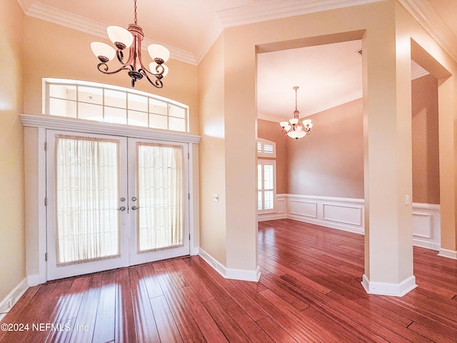 foyer featuring a chandelier, wood-type flooring, french doors, and ornamental molding