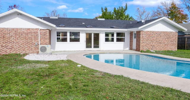 rear view of house featuring ac unit and a lawn