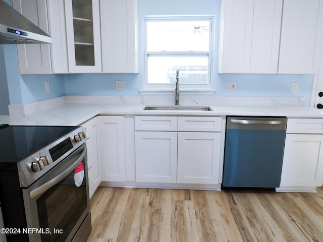 kitchen with white cabinetry, sink, wall chimney exhaust hood, and stainless steel appliances